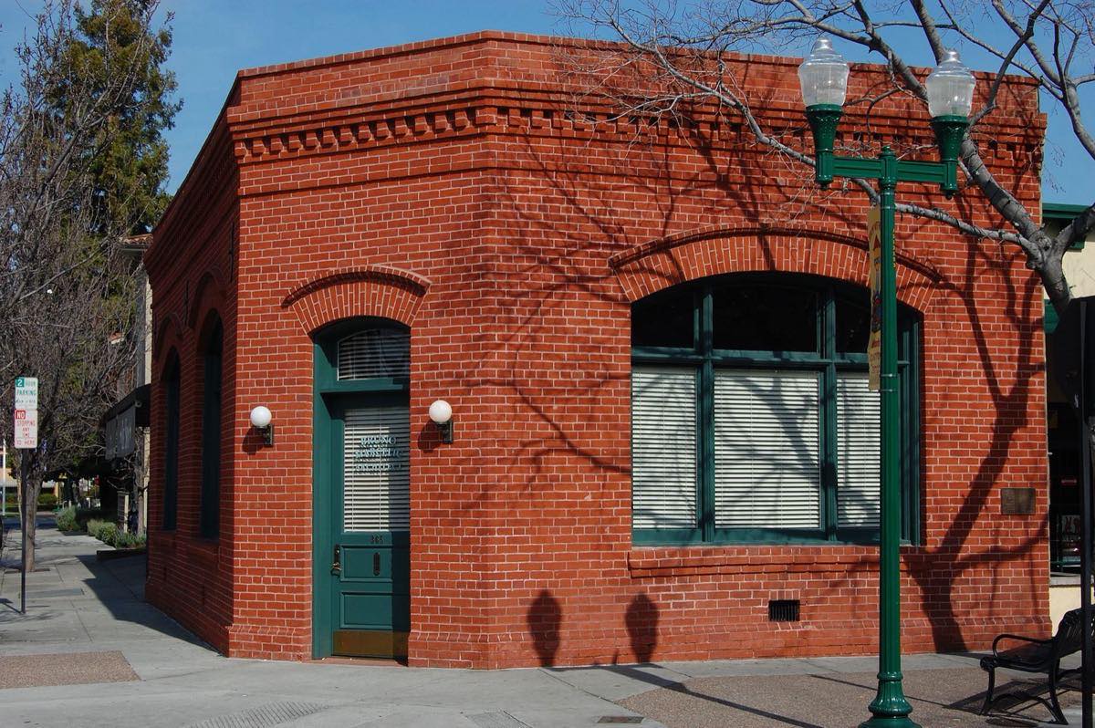 The red-brick Farley Building, the old Bank of Campbell, on a downtown corner of E. Campbell Avenue with a green street lamp