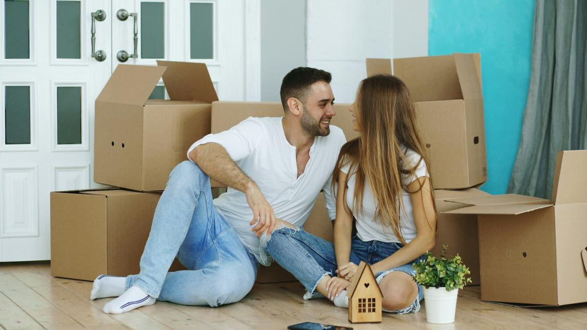 Couple sitting among moving boxes in their new home