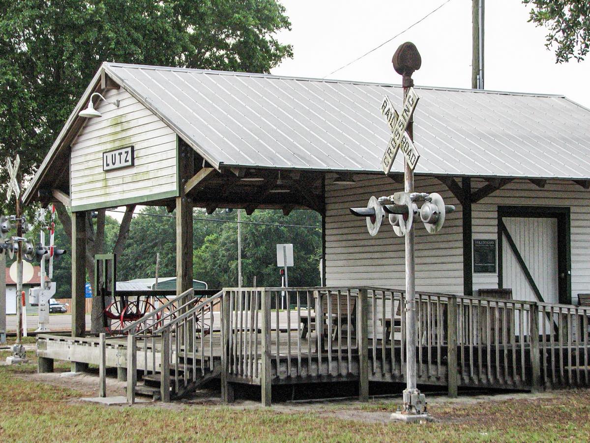 Close view of the Lutz depot replica, its metal roof and the vintage crossbuck signal