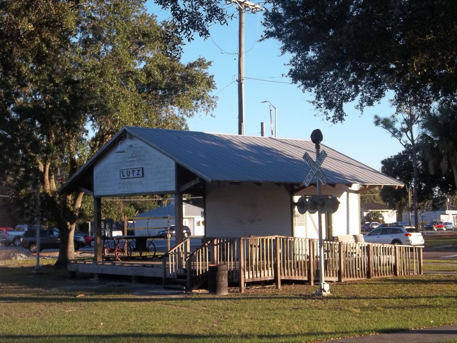 The rebuilt Lutz train depot with its LUTZ sign and railroad crossing signal under a blue sky at Lutz-Lake Fern Road and US 41