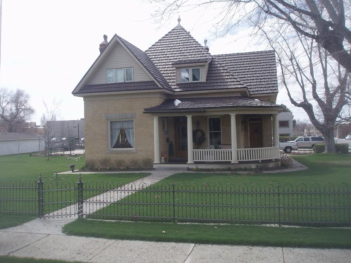 Brick bungalow with front porch and iron fence in the Bountiful historic district