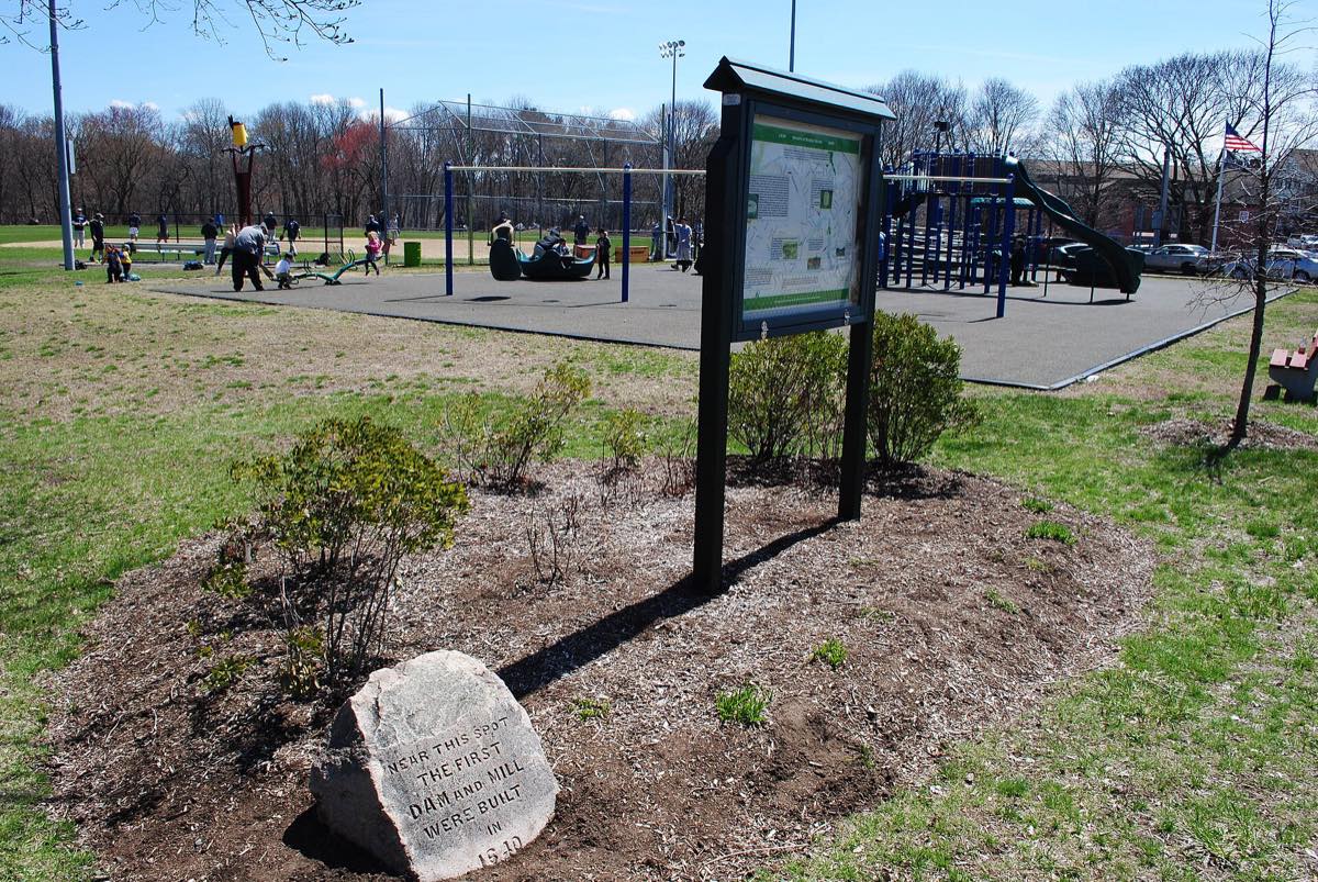 Condon Park beside Mother Brook in East Dedham, with the first-mill marker stone and a playground