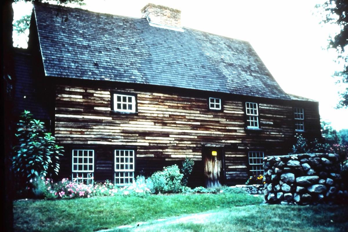 Fairbanks House at 511 East Street, the weathered timber-frame First Period house with its stone wall and garden