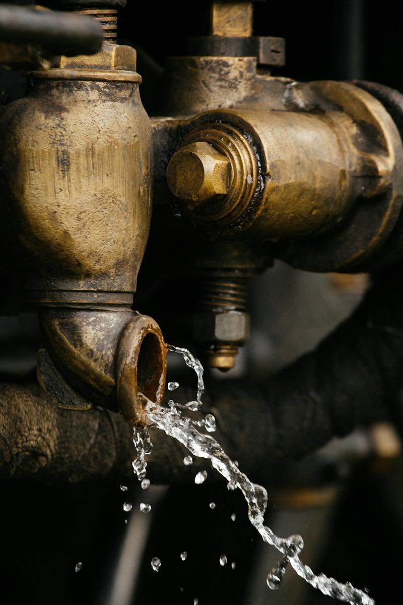 A drop of water forming on a brass pipe fitting