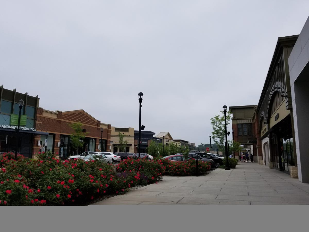 Open-air storefront walkway with rose beds at The Shops at Nanuet