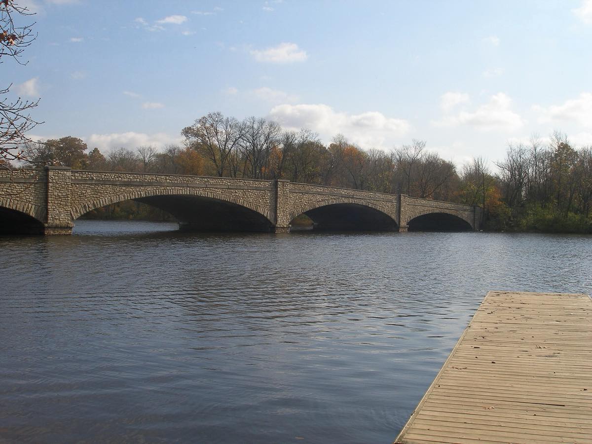 The stone-arch Harrison Street Bridge crossing Lake Carnegie, seen from a boat dock