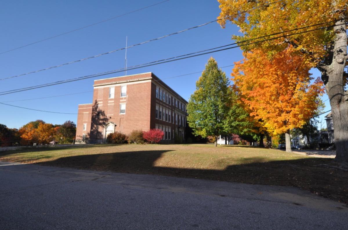 The old Somersworth High School on Grand St, home of NH Historical Marker No. 280, with autumn maples